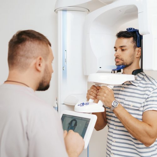 Doctor and patient using x-ray machine. Computer diagnostics. Dental tomography